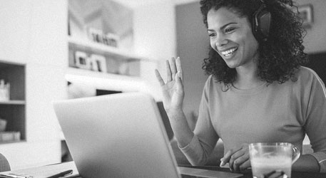 Woman with headet smiling at laptop