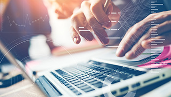 Hands typing on a laptop